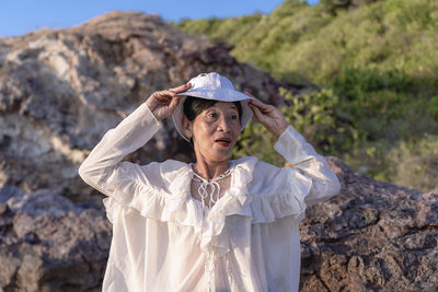 Portrait of a happy mature woman smiling outdoors. happy smiling mature woman on the rock 