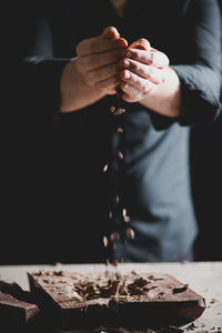 Close-up of baker's hands breaking chocolate