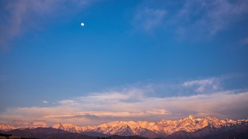 Scenic view of snowcapped mountains against sky at night