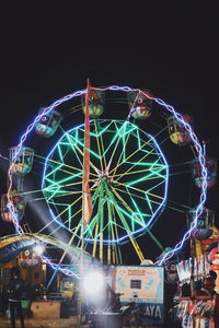 Low angle view of illuminated ferris wheel against sky at night