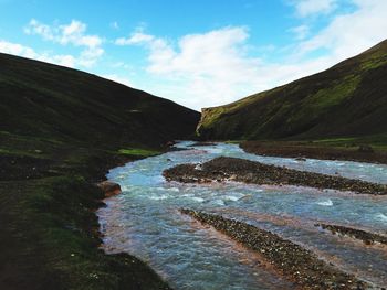 Scenic view of river amidst mountains against sky