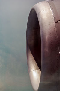 Close-up of airplane jet engine against sky