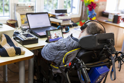 Mature man watching movie on laptop at rehabilitation center