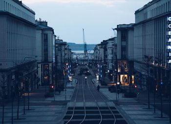 Railroad tracks in city against sky