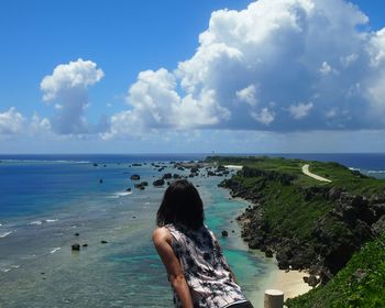 Rear view of woman standing against sea