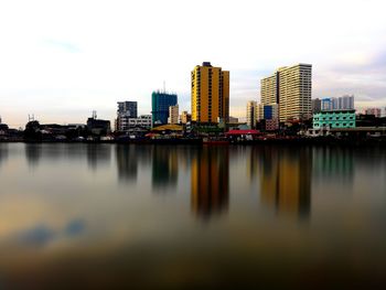 Reflection of city in water against sky