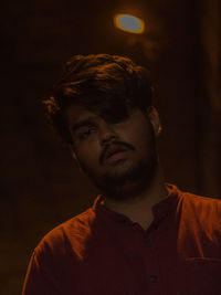 Close-up portrait of young man standing outdoors at night