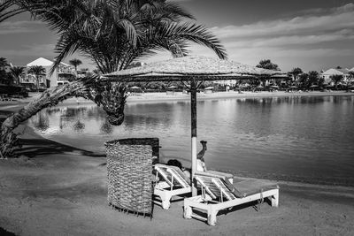 Chairs by swimming pool against sky