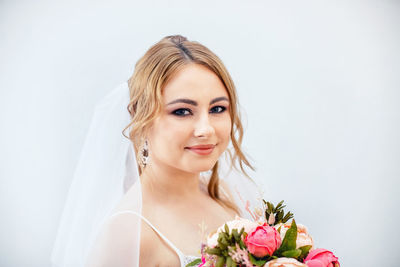 Portrait of a smiling young woman against white background