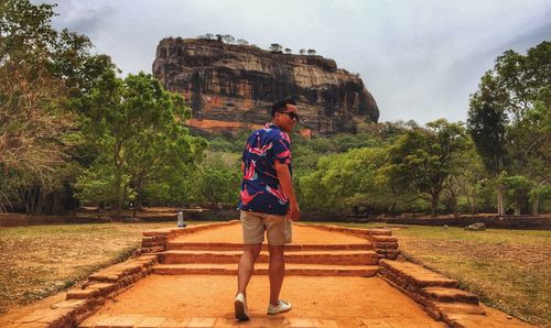 Rear view of man walking at sigiriya