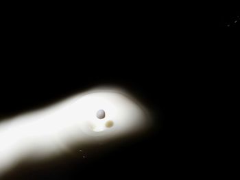 Close-up of water drop falling on black background