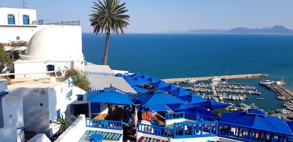 High angle view of buildings by sea against sky