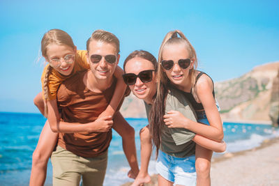 Portrait of smiling family wearing sunglasses on beach