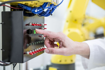 Close-up of woman switching on switch in factory