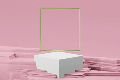 Close-up of stack of colored pencils on table against pink background