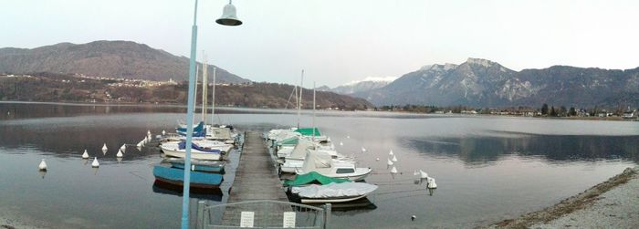 Sailboats moored in lake against sky