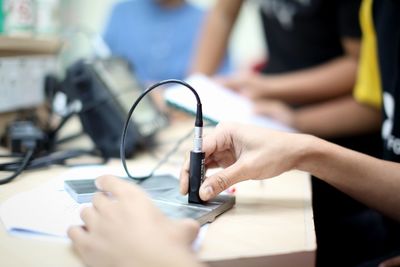 Close-up of woman using mobile phone on table