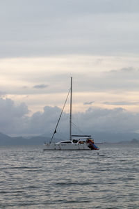 Sailboat sailing on sea against sky during sunset