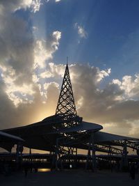 Low angle view of ferris wheel in town against sky during sunset