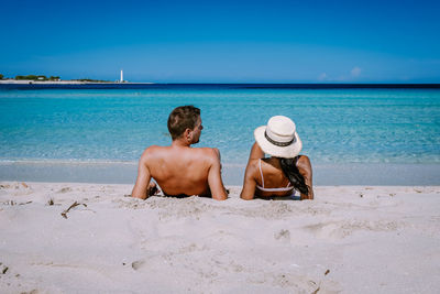 Friends on beach against sky