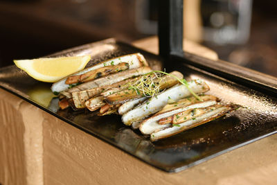 The shells knives, parsley and half a lemon on black plate