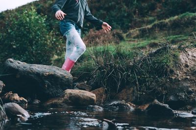 Low section of man jumping in water