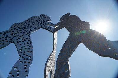 Low angle view of metal structure against blue sky