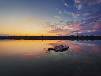 Old, rusty catamaran frame forgotten on the pond. scenery landscape, peaceful sunset sky