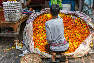 Rear view of man for sale at market stall