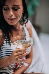 Close-up portrait of a young woman drinking glass