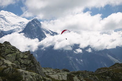 Paraglider over rocky mountain landscape