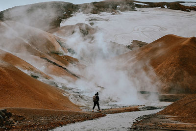 Rear view of person standing on shore