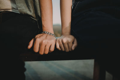 Close-up midsection of couple sitting on bench