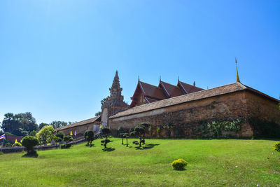 Built structure on field against clear blue sky