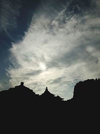 Low angle view of silhouette mountain against clouds