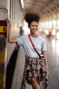 Portrait of smiling young woman standing in city