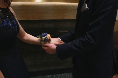 Midsection of couple holding hands during wedding ceremony