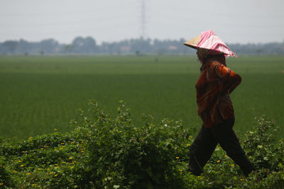 Full length of woman standing in farm against sky