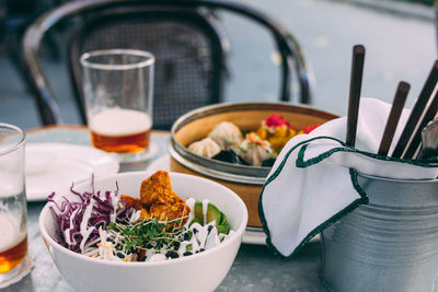 Pan-asian food - different dim sums in a bamboo bowl and salad. lunch for two with beer