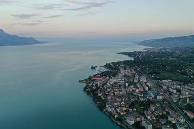 High angle view of townscape by sea against sky during sunset