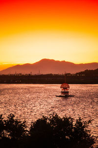 Scenic view of sea against dramatic sky during sunset