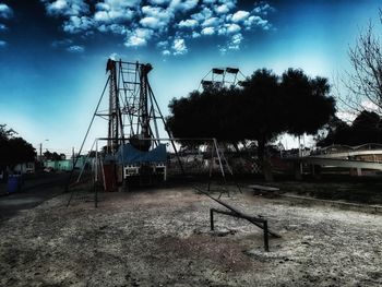 Metallic structure on field against sky