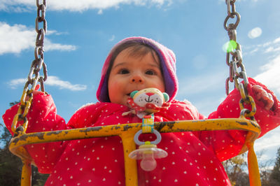 Portrait of cute girl holding red during winter
