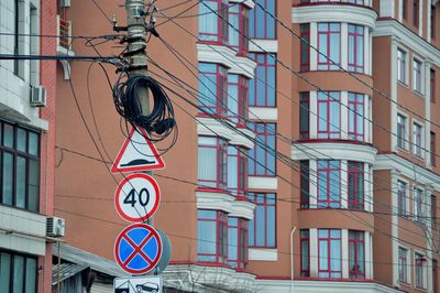 Low angle view of road sign against buildings in city