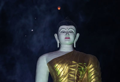 Statue of buddha against black background