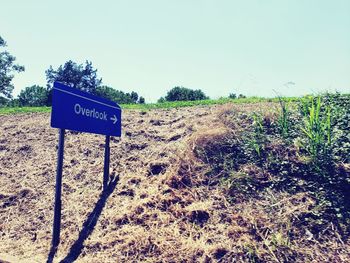 Information sign on field against clear sky