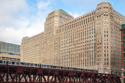 Low angle view of modern building against cloudy sky