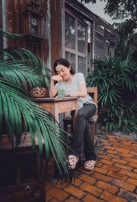 Portrait of young woman sitting on street