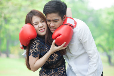 Young couple wearing boxing gloves at park