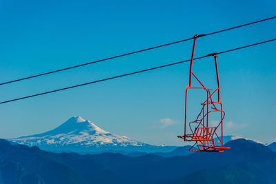 Low angle view of snowcapped mountain against blue sky